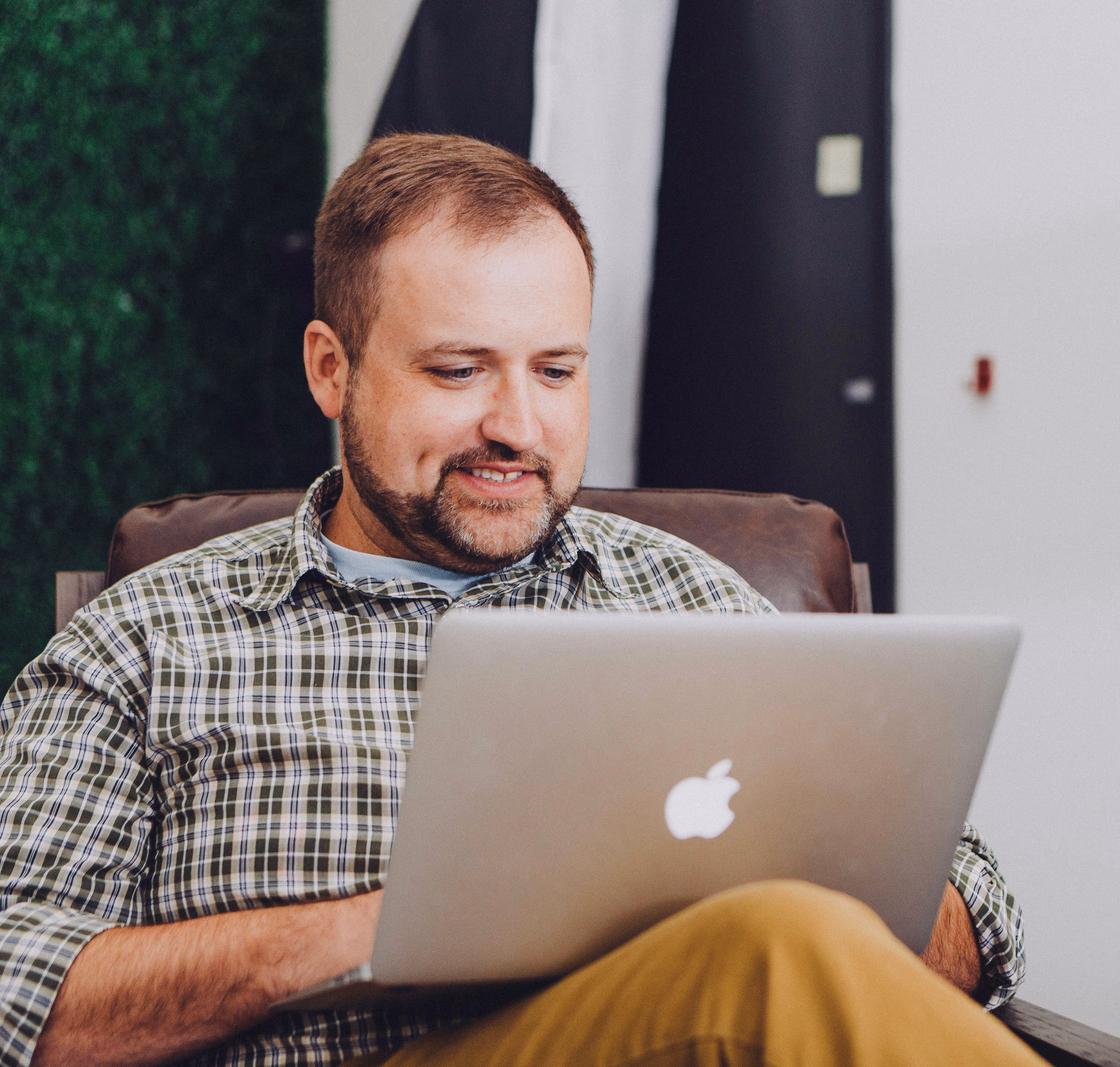 man smiling and using MacBook
